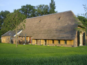 Отель Staying in a thatched barn with bedroom and box bed beautiful view Achterhoek  Geesteren